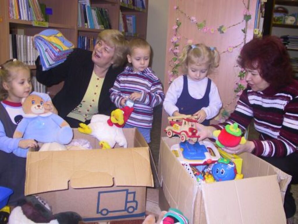 Arī bibliotekāres Ilze Nātre (no kreisās) un Zoja Nikolajeva  uz brīdi sajūtas kā bērnībā, ar māsiņām Gintu un Līgu Ozoliņām un Endiju Graudiņu apskatot saņemtās dāvanas.
Autors: Sandra Pētersone