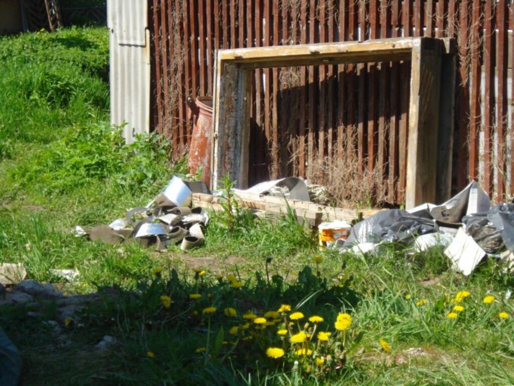 Smiltenes centrs tiek uzposts ļoti bieži, taču ielūkojoties nedaudz dziļāk skats nav tik patīkams. Kāds aiz ugunsdzēsēju depo ierīkojis sev „piemīlīgu” pasēdēšanas vietu. Interesanti būtu zināt, kuram jāsavāc šie atkritumi?Pie garāžiņām aiz ugunsdzēsēju depo paveras daudz nepatīkamāks skats. Šeit, šķiet , darbojas šāds princips - kādēļ gan savākt pērnā gada atkritumus, ja tie tik veiksmīgi ieauguši jaunajā zālītē un pienenēs? 
Autors: Baiba Šķērīte