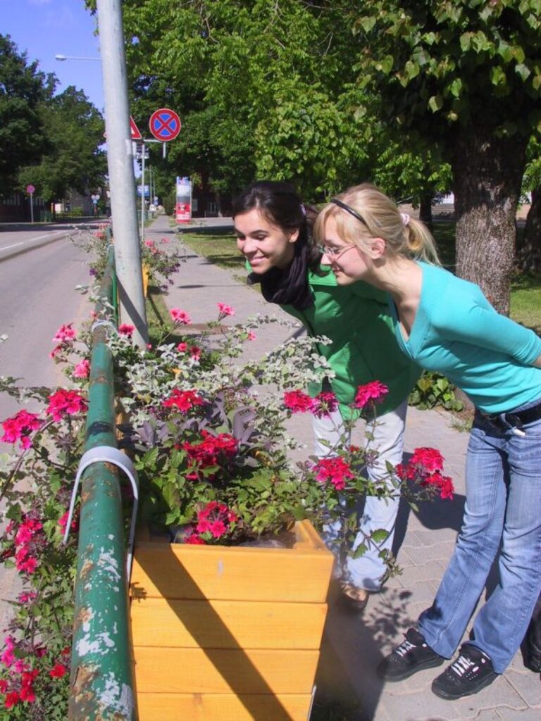 Strencēnietes Alise Ziemule (no kreisās) un Paula Vaivade uzreiz ievēroja jaunās puķu kastes pilsētas centrā. “Tagad ir skaistāk, košāk. Var saprast, ka tas ir pilsētas centrs,” saka jaunietes. 
Autors: Sandra Pētersone