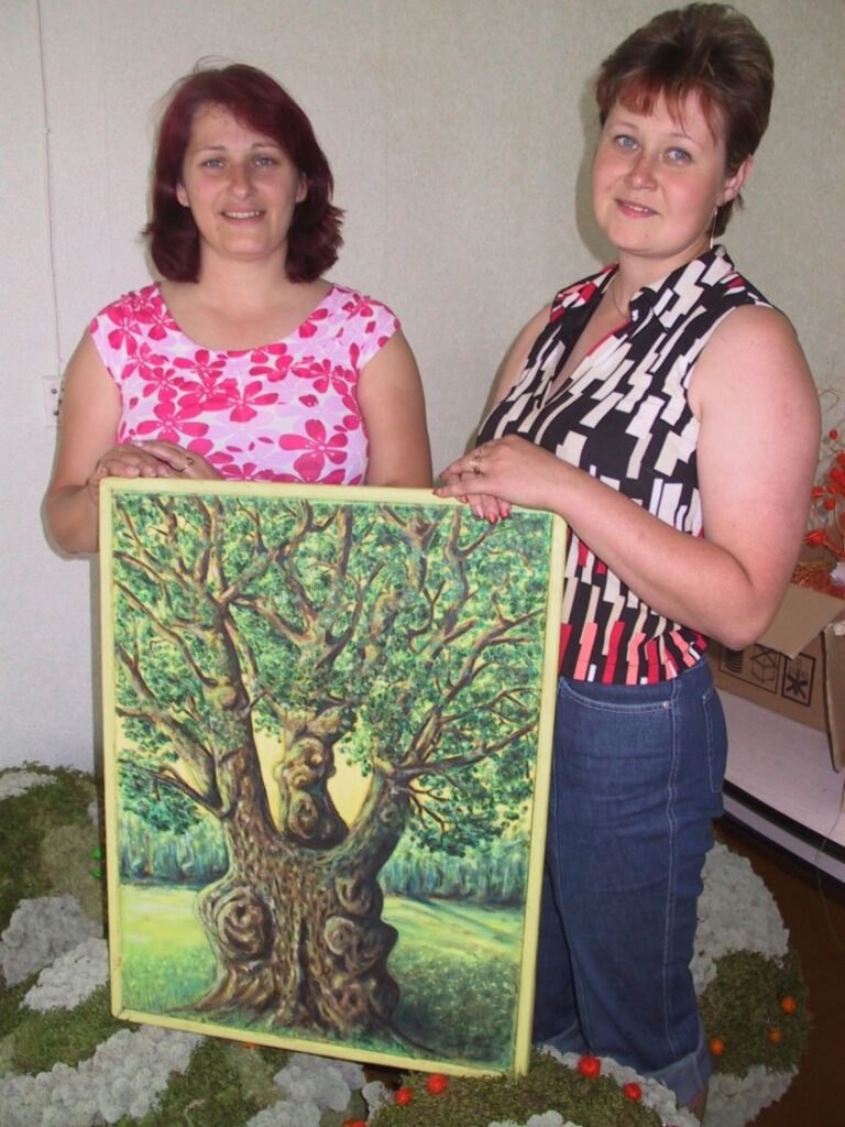 Strenču pilsētas astoņdesmitgadei veltītajās izstādēs varēs redzēt arī naivista Nikolaja Stūra gleznas, arī šo, kurā ieskatīties piedāvā pilsētas kultūras dzīves organizatores Solvita Tēberga (no kreisās) un Daiga Beitika
Autors: Sandra Pētersone