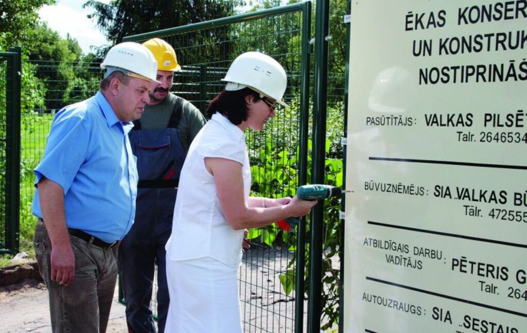 Valkas domes priekšsēdētāja Unda Ozoliņa būvdarbu vadītāja Pētera Gudrinieka uzraudzībā beidz nostiprināt plāksni ar informāciju par objektā notiekošo.
Autors: Aldis Dubļāns