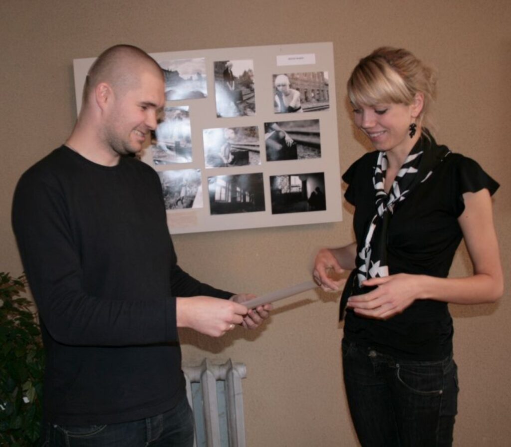 Vīra Reiņa Dorša vietā balvu no žūrijas priekšsēža Ernesta Lībieša rokām saņem fotogrāfa sieva un modele Līva. 
Autors: Aldis Dubļāns