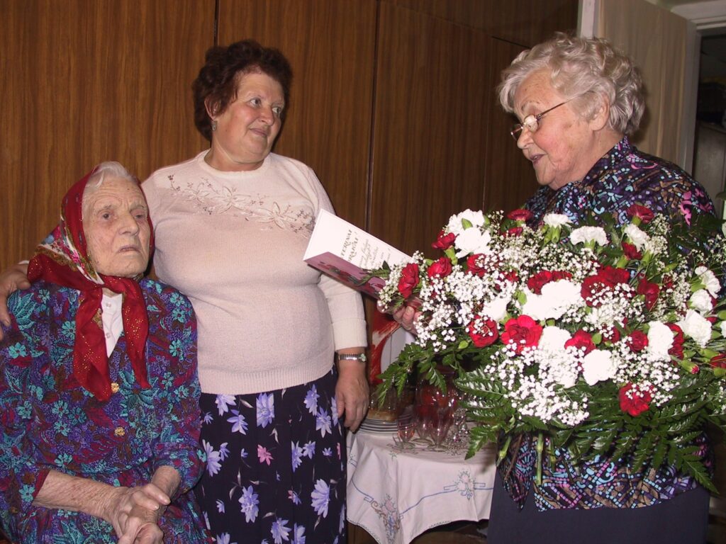 Simtgadnieci Jekaterinu Mudraku (no kreisās) dzimšanas dienā sveica Velta Tauriņa un citi ciemiņi no Smiltenes pensionāru apvienības un domes. Par jubilāri rūpējas viņas meita Pelageja Druska (blakus).
Autors: Sandra Pētersone