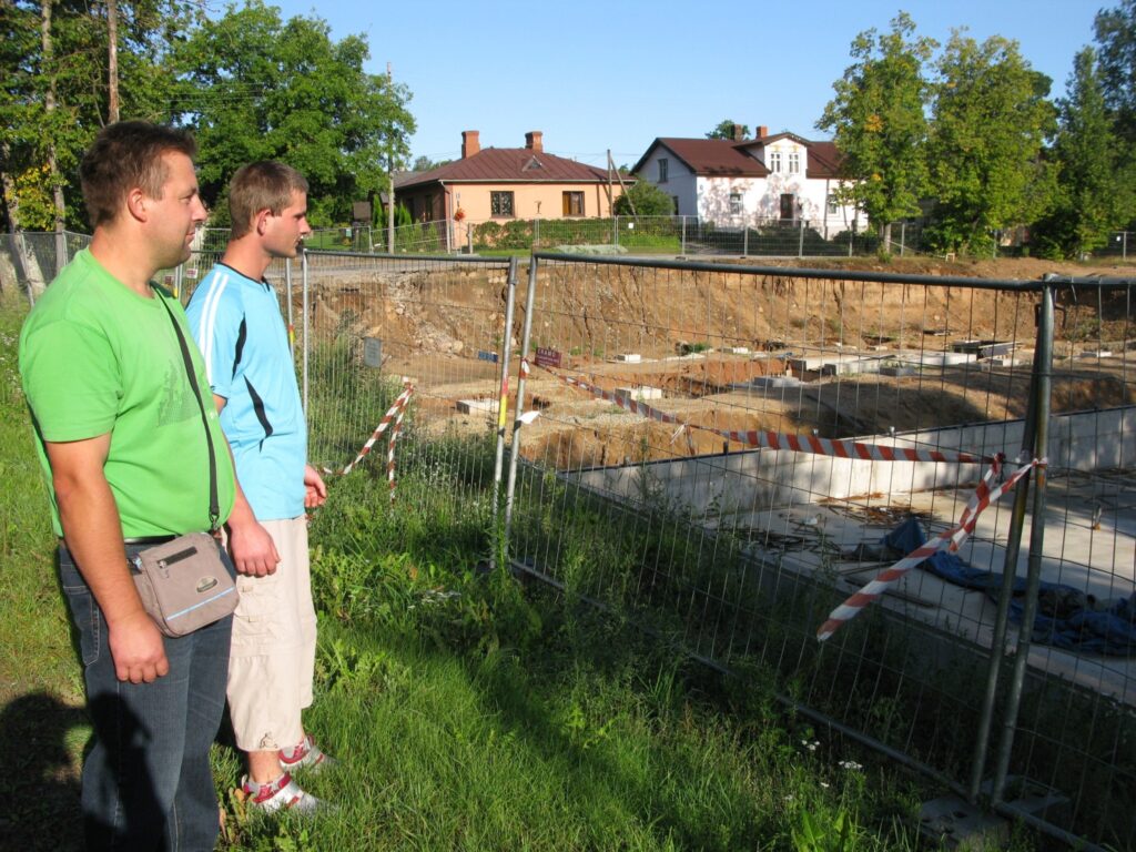 Igaunijas uzņēmēju solījumi šogad līdz 1. septembrim Smiltenē uzcelt peldbaseinu nav piepildījušies. Garāmgājēji, arī Aigars Gusmanis (no kreisās) un Kaspars Līnis, jau vairākus mēnešus Kalēju ielā redz  tikai vientulīgu būvlaukumu.
Autors: Sandra Pētersone