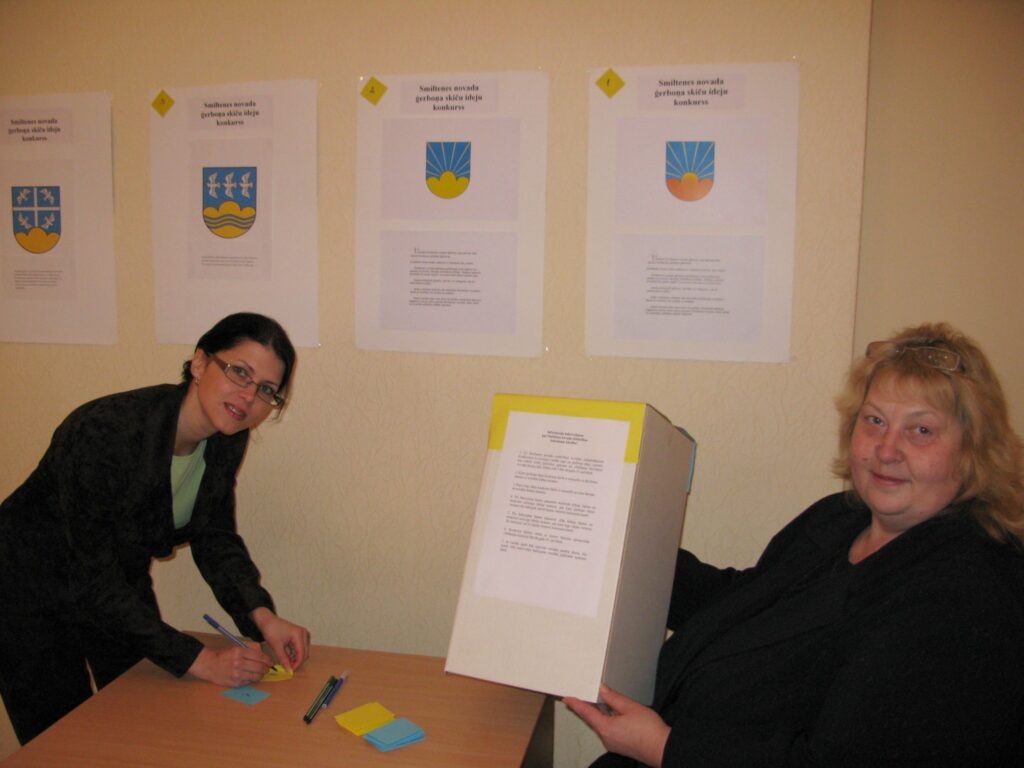 Savu izvēli, balsojot par Smiltenes novada ģerboņa un logo skiču variantu, jau izdarījušas tūrisma informācijas centra speciālistes Sanda Akmentiņa (no kreisās) un Dagnija Kalniņa. 
Autors: Sandra Pētersone