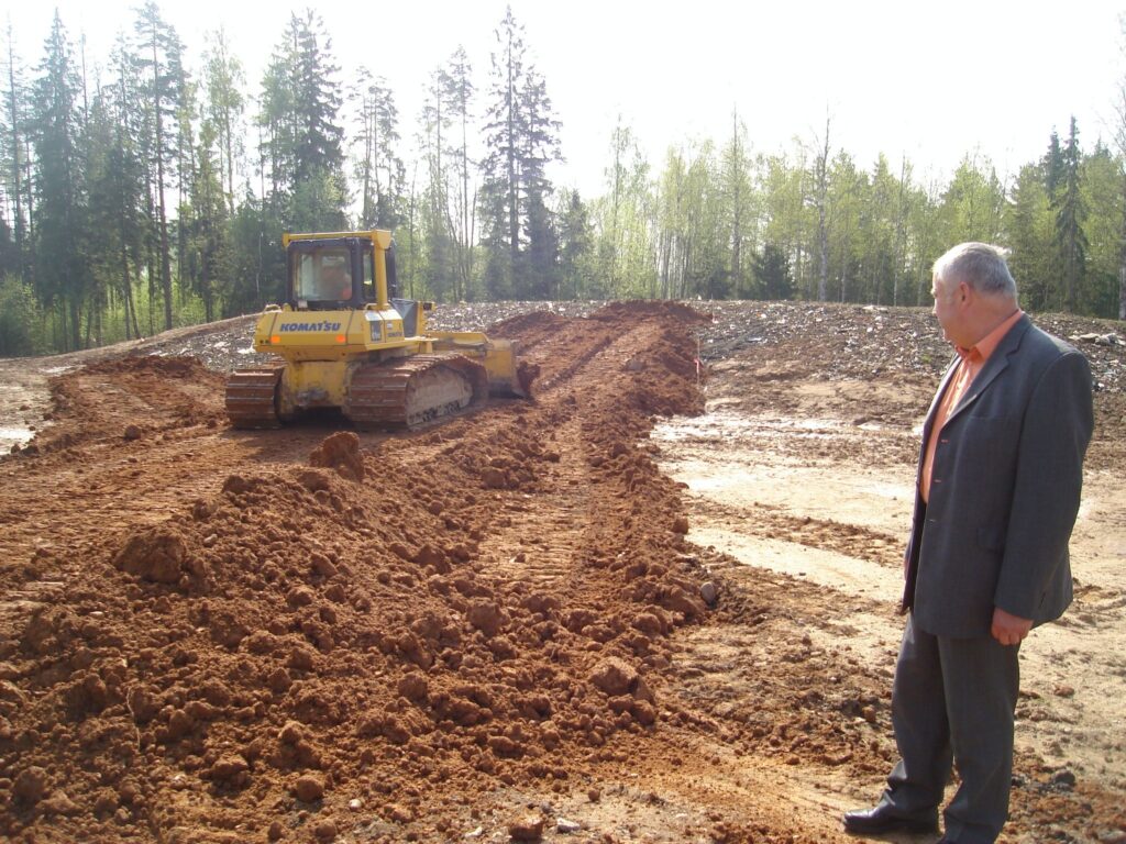 Launkalnes pagasta pārvaldes vadītāju Māri Lazdiņu interesē, cik daudz pagasta atkritumu izgāztuves rekultivācijā paveikusi firma “Lauku apgāds un meliorācija”. Pie buldozera stūres -  Francis Spirido. 
Autors: Sandra Pētersone