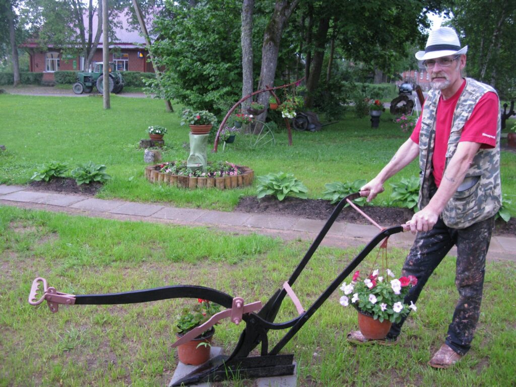Palsmanietis Andrejs Tamme  pagalmu pie savas daudzdzīvokļu mājas  izdaiļojis ar paša kokgriezumiem un citiem dekoratīviem priekšmetiem. Pēdējais “jaunpienācējs” ir šis arkls, ko Andreja dzīvesbiedre Jūsma izrotājusi ar puķēm.
Autors: Sandra Pētersone