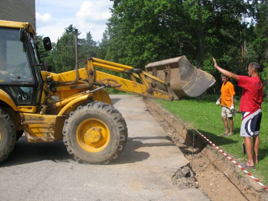Pie tehnikuma mācību korpusa Kalnamuižā firmas “Ceļinieks 01” strādnieki Agris Janelsiņš (no kreisās) un Ritvars Vāravs būvē vecajam asfaltam piegulošu jaunu borta līniju. 
Autors: Sandra Pētersone