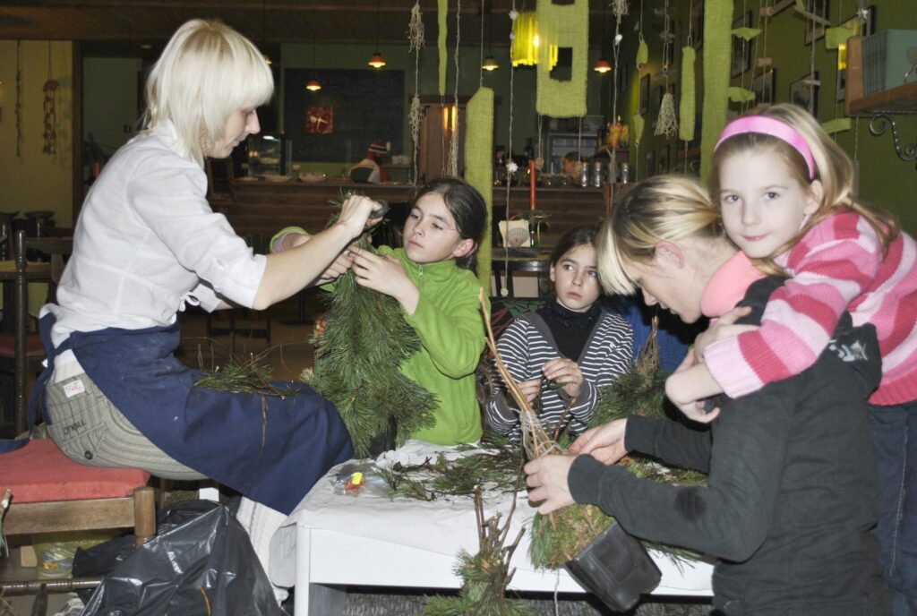 Smiltenes bērnu brīvā laika centra “Ligzdiņa” audzēkņi kopā ar mammām šonedēļ darināja Ziemassvētku eglītes, ko dāvināt saviem labvēļiem. Floristikas nodarbības viņiem vada “Mūzas” īpašniece Inguna Ūdre (no kreisās). 
Autors: Sandra Pētersone