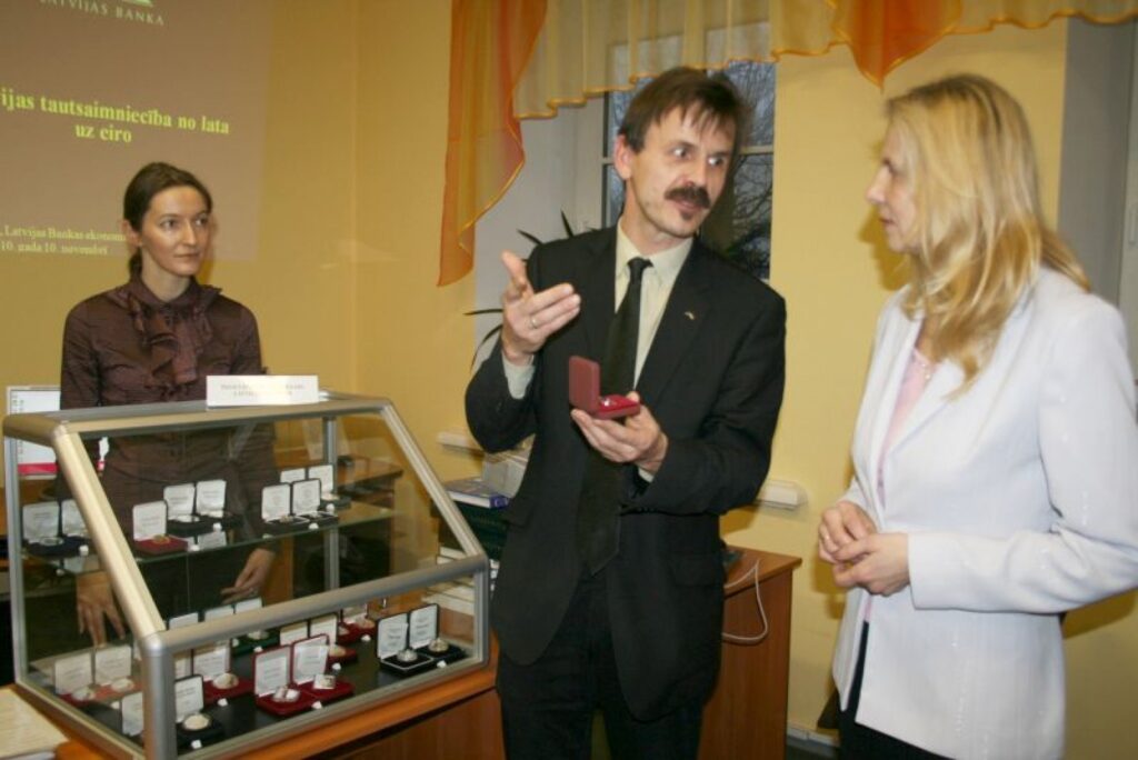 Latvijas Bankas pārstāvis Kristaps Otersons ar lepnumu rāda bibliotekārei Aldai Liukei “Gada monētu 2010” pasaulē.
Autors: Sandra Pētersone