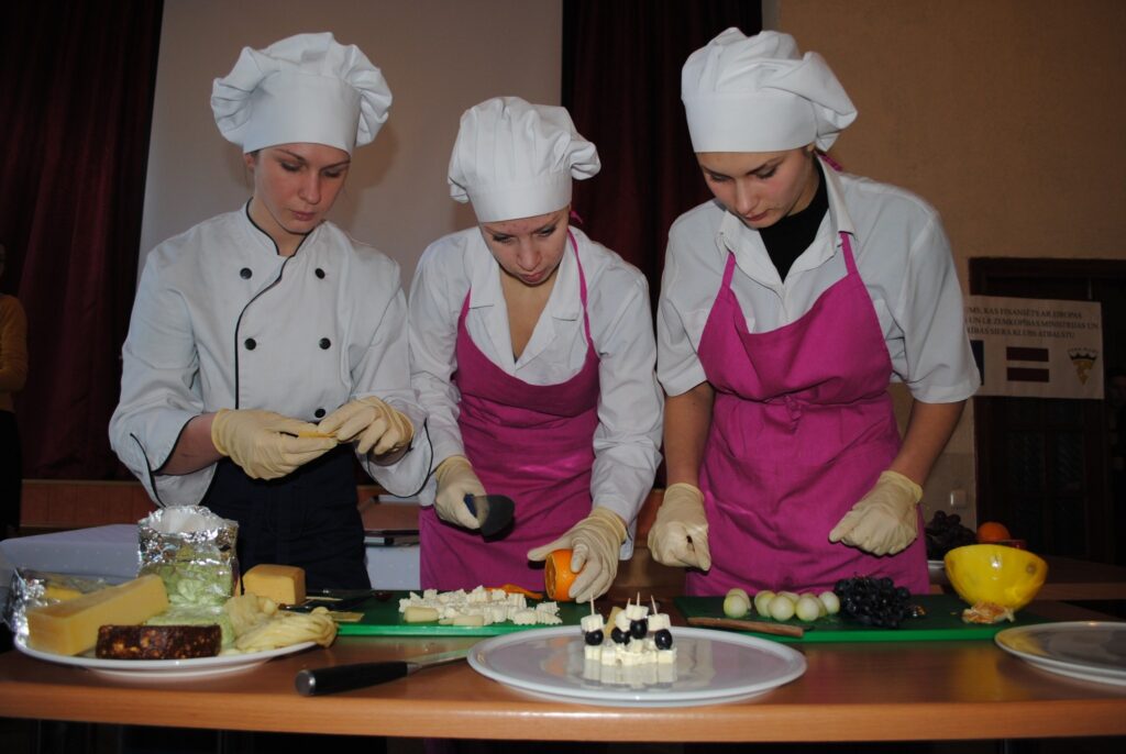 Kā pagatavot siera plati, rādīja Smiltenes Valsts tehnikuma - profesionālās vidusskolas audzēknes, topošās ēdināšanas pakalpojumu speciālistes Darja Medvedeva (no labās), Elita Žukova un Kristīne Saldābola. 
Autors: Sandra Pētersone