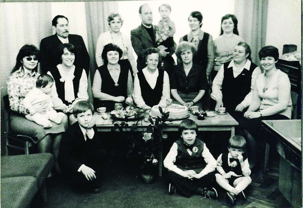 Gandrīz visa “Darba Karoga” saime svin kopējus svētkus. Pirmajā rindā no kreisās Ilze Galkina, Silvija Dorša, Vija Knostenberga, Emma Mazjāne, Maiga Silāja, Ilga Sudraba, Ilze Brice. Otrajā rindā: Jānis Locāns, Aira Vjaževiča, viesis no laikraksta “Sovetskaja Latvija” Jevgeņijs Mažāns, Mārīte Dzene un Mudīte Pole. 
                                                                                                                                                                                                                                                 
Autors:  NO AIRAS VJAŽEVIČAS ARHĪVA