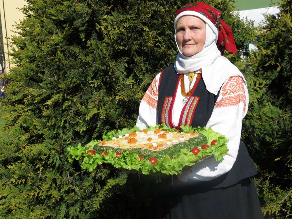





















SIERA UN MAIZES SVĒTKU
SĀĻĀ TORTE
„KAZDANGAS SIERU AKORDS”

Gatavoja: Gundars Sisenis,
Kazdangas pagasts, Aizputes novads.
Tortes svars: 4,4, kg.

























Pirmā kārta: 300 g SIA „Dona” rudzu maizes, 400 g Kazdangas siera ar ķiplokiem un garšvielām, 300 g tomātu, 2 daiviņas ķiploka, 10 g čili pipara, 150 g bekona, olīveļļa, 5 kaltēti tomāti, pētersīļu zaļumi.
Maizi sagriež plānās šķēlēs, izkārto uz plāts. Sieru sagriež un rūpīgi sablenderē. Tomātus noblanšē, novelk miziņas, sagriež, izņem sēklas, kopā ar saspiestu ķiploku, čili piparu un sasmalcinātiem pētersīļiem izvāra ievārījumu.
Bekonu sacep kraukšķos, atdzesē, sablenderē. Siera masu samaisa ar tomātu ievārījumu, bekona pulveri un iegūto krēmu liek uz maizes kārtas, kura ir pārsmērēta ar olīveļļu, kaltēto tomātu un pētersīļu maisījumu.
Otrā kārta: 100 g „Lāču”  rupjmaizes rīvmaizes, 5 olas, cepamais pulveris, sāls, šķipsniņa cukura, pāris karotes ruma.
Krēmam: 300 g Kazdangas siera ar dillēm, 150 g sviesta, 300 g pīles gaļas, olīveļļa, 200 ml sarkanvīna,  garšvielas, sezama eļļa. 
Izcep biskvītu: olu dzeltenumus atdala no baltumiem, saputo un iemaisa rīvmaizē. Atdzisušo biskvītu pārslaka ar rumu.
Gatavo krēmu: pīles galu sagriež gabaliņos, apcep olīveļļā, tad ielej sarkanvīnu, pievieno garšvielas un izsautē, atdzesē, pievieno sezama eļļu, sablenderē. 
Sieru sagriež kubiņos, sablenderē, samaisa ar saputotu sviestu, ar pīles gaļas pastēti, klāj uz biskvīta.
Trešā kārta: 300 g SIA N.Bomja maizes ceptuves „Lielezers” saldskābās maizes, 600 g Kazdangas siera ar ķimenēm, 350 g Kazdangas skābā krējuma, 40 g kaņepju sēklu, kaņepju eļļa. 
Uz tortes otrās kārtas liek plāni sagrieztu maizi. Pārsmērē ar kaņepju eļļu.
Gatavo krēmu: sagriež sieru, sablenderē ar krējumu un kaņepju sēklām. Klāj uz maizes. Šo krēmu atstāj tortes virskārtai.
Ceturtā kārta: 300 g SIA „Saldus maiznieks” rudzu maizes, 300 g Kazdangas siera ar papriku, pipariem un zaļumiem, 150 g Kazdangas saldā krējuma, 1 ēdamkarote Dižonas sinepju (var ņemt franču sinepes), 80 g kviešu asnu pulvera, olīveļļa ar zaļumiem. 
Maizi sagriež plānās šķēlēs un pārsmērē ar olīveļļu, kura samaisīta ar sakapātiem zaļumiem.
Gatavo krēmu: sieru sagriež gabaliņos un sablenderē ar saldo krējumu, sinepēm, asnu pulveri, pārziež maizi.
Tortes garnēšanai: 1 kg ķiršu tomātiņu, cukurs un ūdens (1:1), sauja piparmētru, zaļās pistācijas, dīksti, zaļumi, melnais sezams, kaperi.
Izvāra sīrupu, kuram pievienotas piparmētras, tomātiņus noblanšē, novelk miziņas, pārgriež uz pusēm un liek uz 12 stundām sīrupā, lai ievelkas. 
Uz tortes virskārtas klāj krēmu, kurš likts virs trešās kārtas maizes (tāpēc krēms vārīts vairāk), rotā ar tomātiņu pusītēm, zaļajām pistācijām, dīkstiem, melno sezamu, kaperiem.
Padomi:
*maizei jābūt nobriedušai, lai varētu sagriezt plānas šķēles,
* torte jāgatavo iepriekšējā vakarā, lai kārtas sasūcas ar krēmu.
 Labu apetīti!
Autors: PUBLICITĀTES