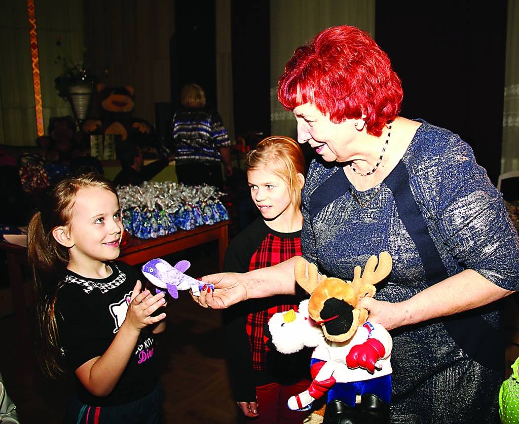Biedrības “Emmaus-Smiltene” valdes priekšsēdētāja Ārija Indrikovska pasniedz pārsteiguma balvas aktīvākajām rotaļu dalībniecēm.