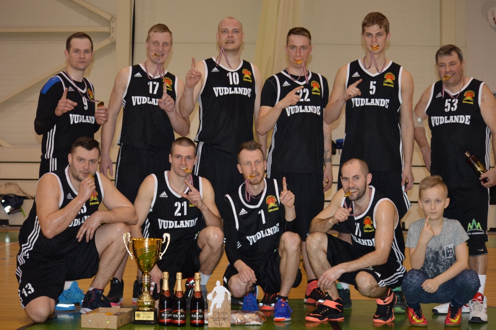 Nu jau piekto gadu pēc kārtas Smiltenes novada čempionātā basketbolā uzvarējusi komanda “Vudlande”: 1. rindā no kreisās  Māris Millers,  Uldis Slapjums, Aivis Junkers, Andis Šteinbergs ar līdzjutēju;  2. rindā no kreisās Jānis Uiska, Rolands Mellis, Kārlis Muižnieks, Gatis Rubņikovičs,  Elvis Kristiāns Šmulāns, Mihails Feldhūns. Klāt nav Kaspars Kozlovskis.