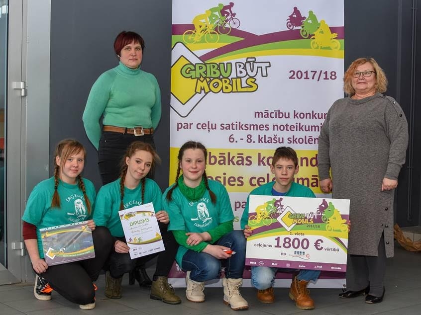 Ērģemes pamatskolas komandas “Jautrie pūčulēni” dalībnieki - Paula Zunde (no kreisās), Elvita Zīle Dica, Emīlija Kondratjeva, Reinis Feldmanis - un konsultējošā skolotāja Agija Reiniece (otrajā rindā no kreisās) tik tiešām var lepoties par godam nopelnīto uzvaru konkursā “Gribu būt mobils”. 
Autors: PUBLICITĀTES FOTO
