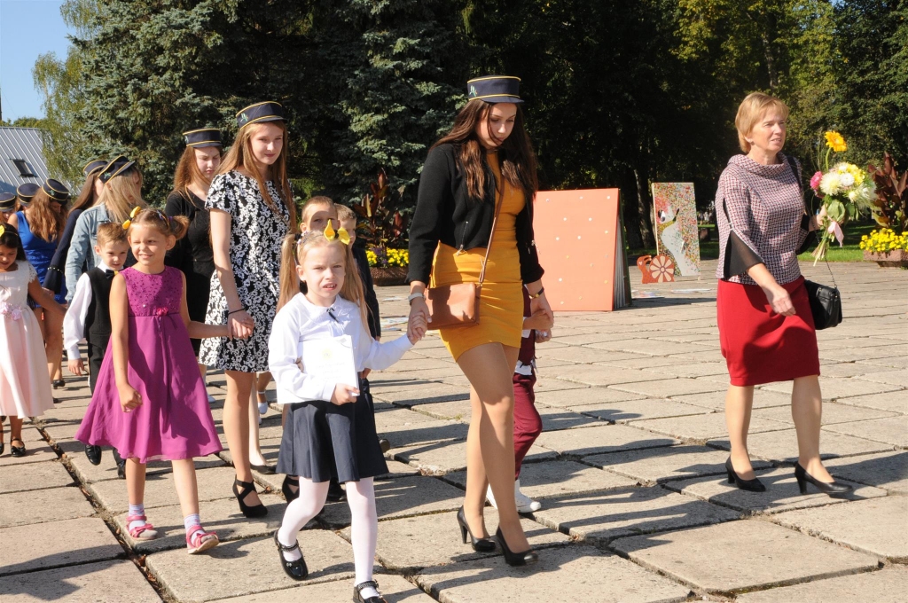Lai drošāk, pirmajā skolas dienā pirmklasnieki stingri turas pie rokas divpadsmitajiem. Tā ir īpaša Valkas Jāņa Cimzes ģimnāzijas tradīcija – kopīgs gājiens un svinīgais svētku pasākums Lugažu laukumā.    
Autors:  INGA KARPOVA