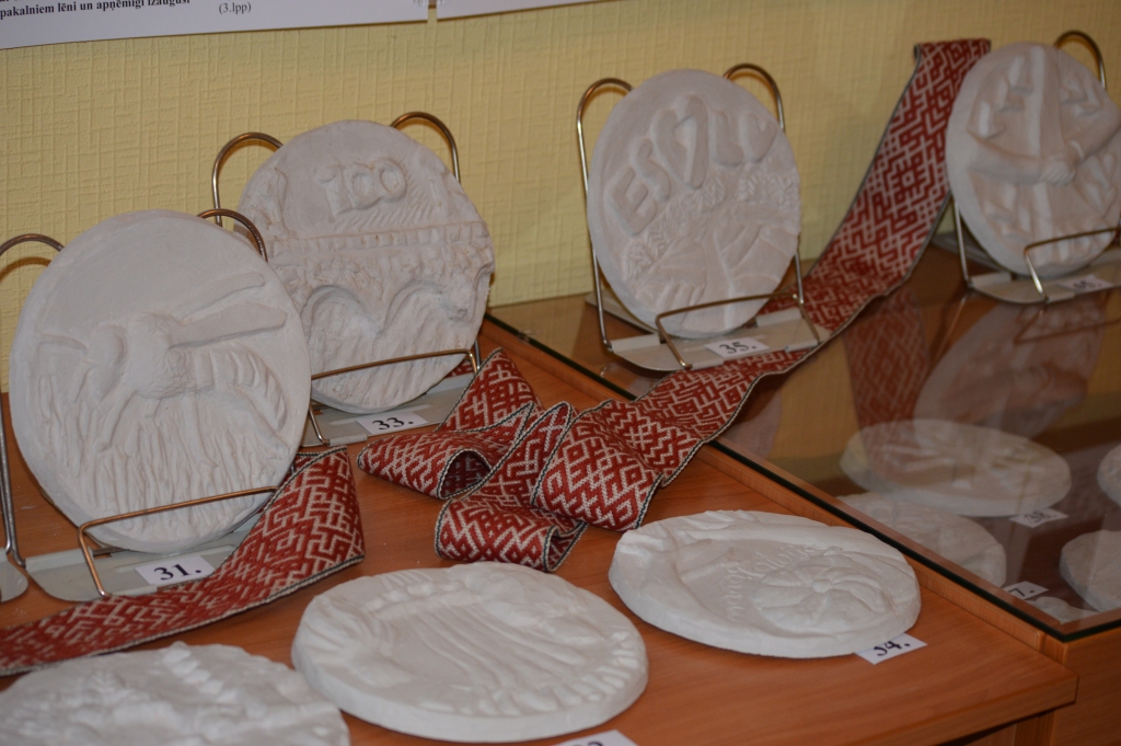 Smiltenes novada bibliotēkā skatot pilsētas mākslas skolas audzēkņu veidotās medaļas, apmeklētāji var balsot par sev tīkamākajām. 
Autors:  SANDRA PĒTERSONE