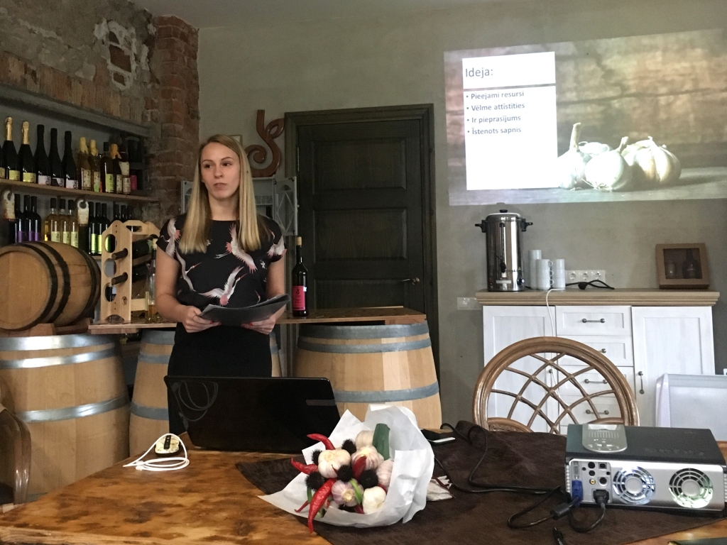 Pagājušā gada mācību pasākuma “Atbalsts lauku jauniešiem uzņēmējdarbības veicināšanai” noslēgumā Naukšēnu vīna darītavā Kristiāna Levija Munce prezentē savu biznesa ideju – ķiploku audzēšanu, to realizāciju un ķiploku izmantošanu floristikā.