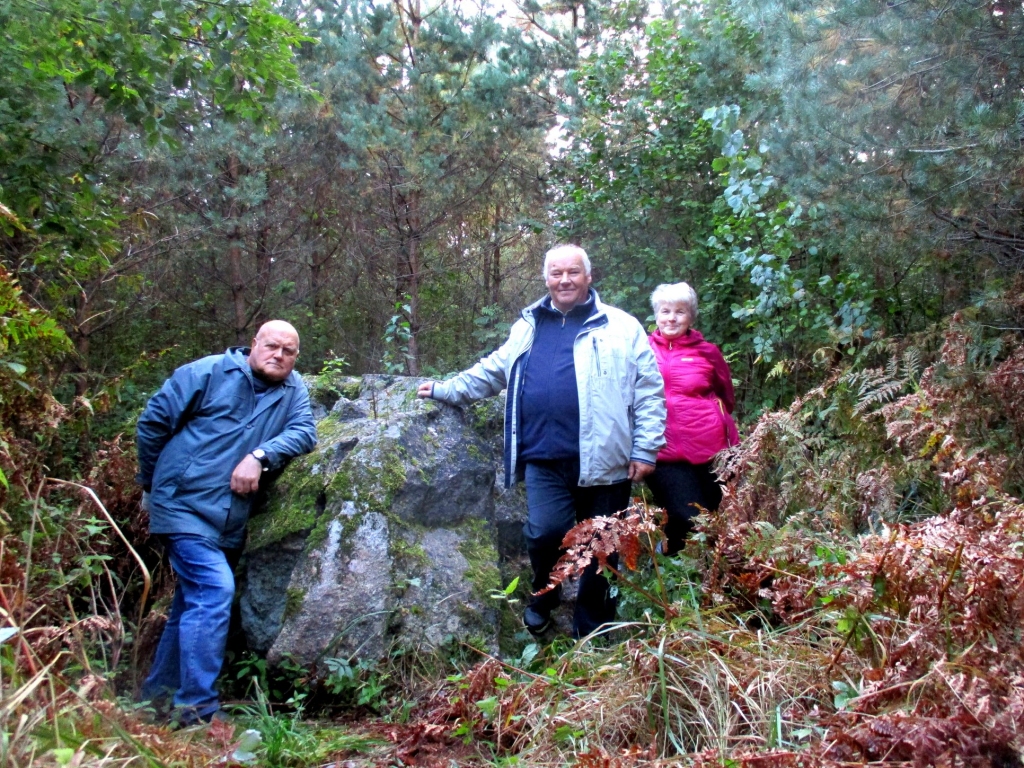 Latvijas izzinātājs Vilnis Reguts zem šī fotouzņēmuma parakstījis: “Esot vislielākais akmens Valkas tuvumā. Saplaisājis. Redzamas atskaldījuma vietas. Nav zināms, cik dziļi iegrimis zemē. Gudri, zinoši cilvēki saka - dižakmens.” Kopā ar V. Regutu valcēnieši Sandra un Dzintars Vilki.                                                       
Autors:  NO PERSONĪGĀ ARHĪVA