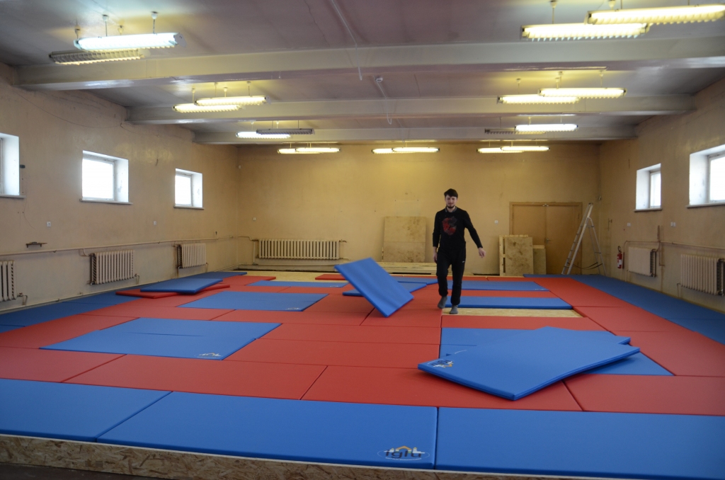 Treneris Edgars Matuks veic “Iglu” paklāju ieklāšanas darbus Valkas novada domes piešķirtajās telpās.