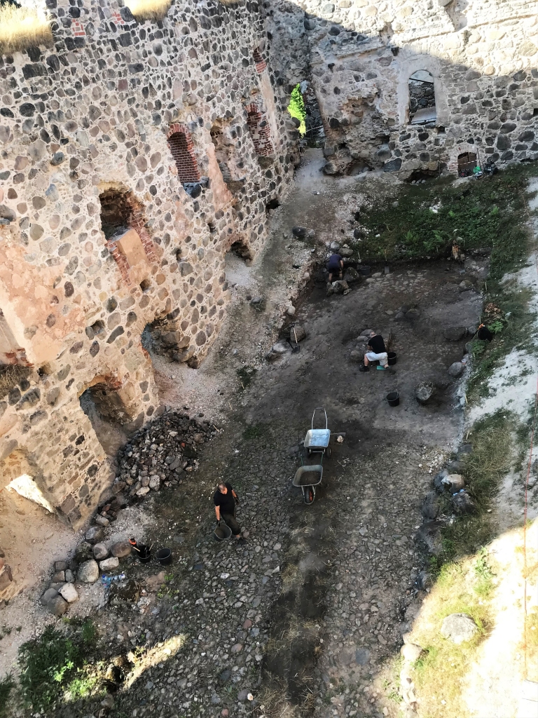 Šādi izskatījās arheoloģisko izrakumu laukums, skatoties no Raunas pilsdrupu torņa, bet šādi (attēlā no labās) – Raunas pils pagalma bruģis pēc attīrīšanas.                                                                                                                                                                                                                                             
Autors: IEVA PLĒTIENA