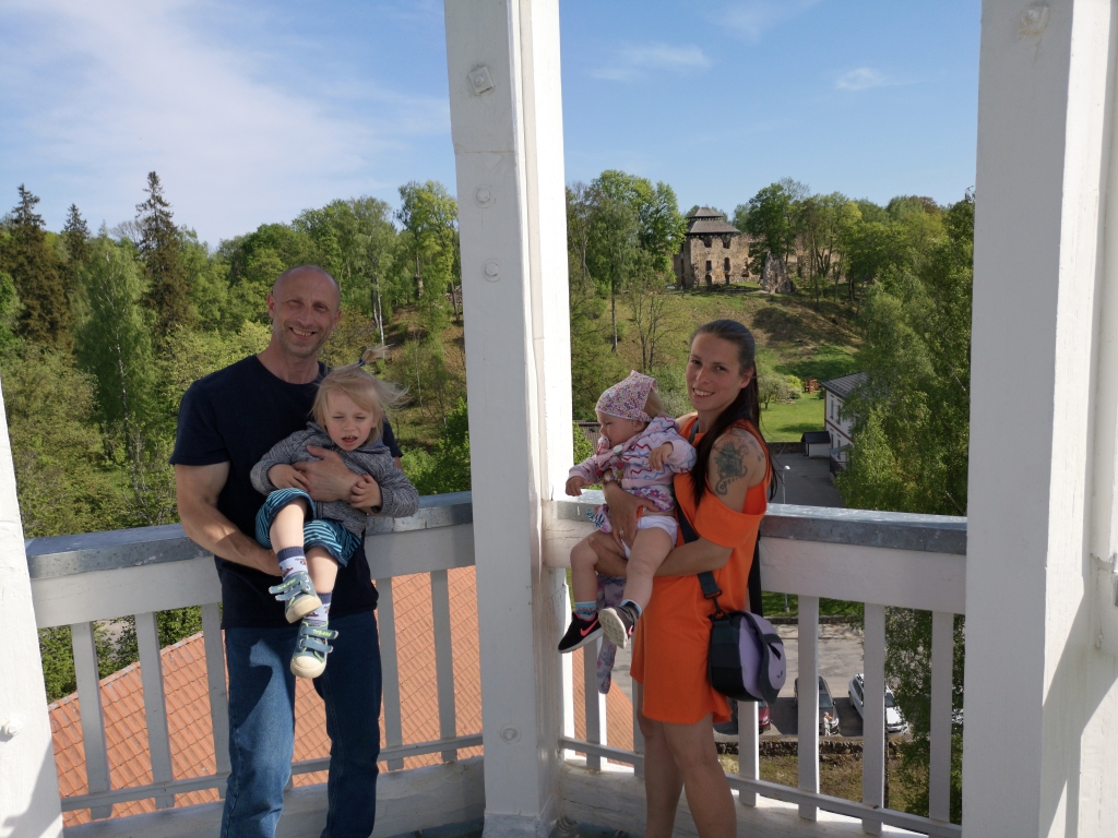 Zaicevu ģimene kopā ar jaunākajiem bērniem Raunas baznīcas tornī, no kura paveras skats uz Raunas pilsdrupām.