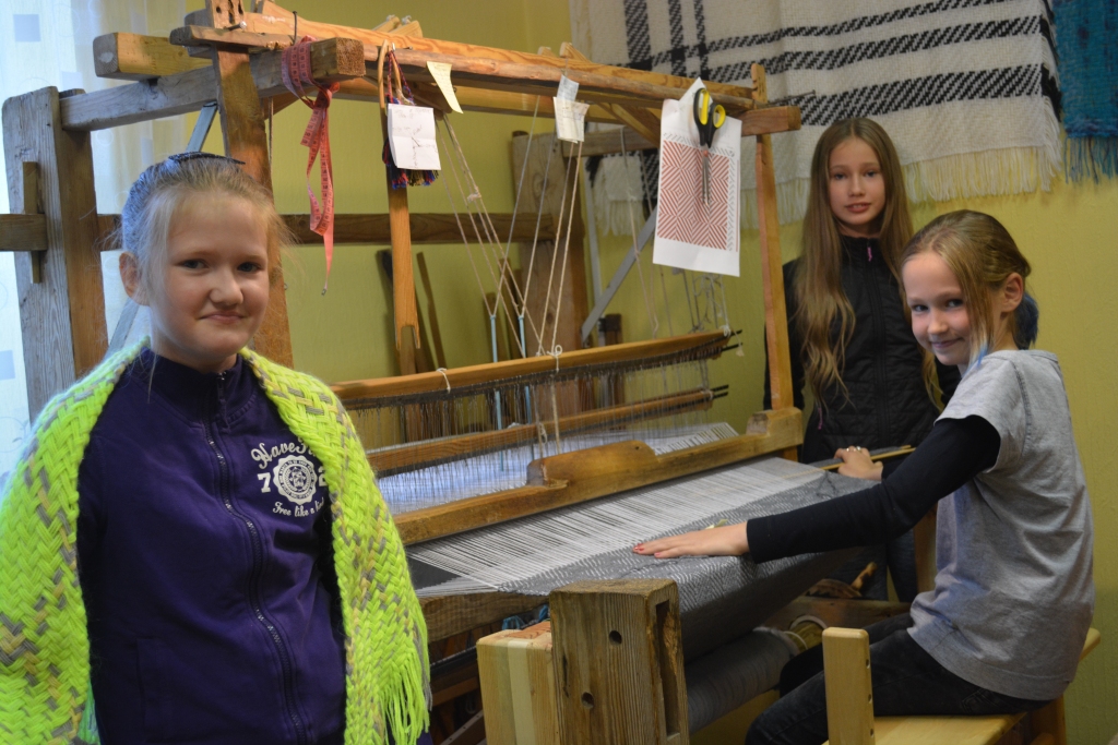 Kristīne Tīna Bodniece (no kreisās), Karlīne Kalniņa un Marta Lāne priecājas par iespēju darboties pie stellēm.                                                                 
Autors: Ilze Fedotova