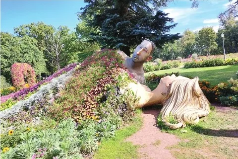 Ziedu skulptūra “Mīlētāji” – zem kokiem guļošie un ar ziedu segu pārklājušies mīlētāji mostas no maģijas pilnā sapņa.