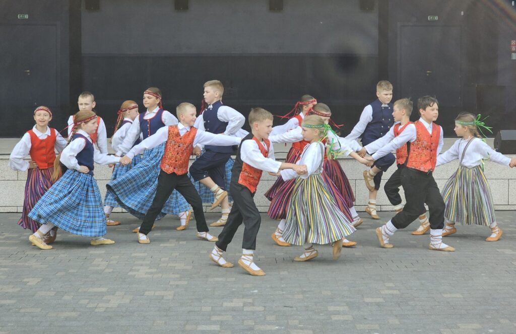 Valkas novada bērnu un jauniešu centra “Mice” tautas deju kolektīvs “Vainadziņš” dejo pie koncertzāles “Latvija”.