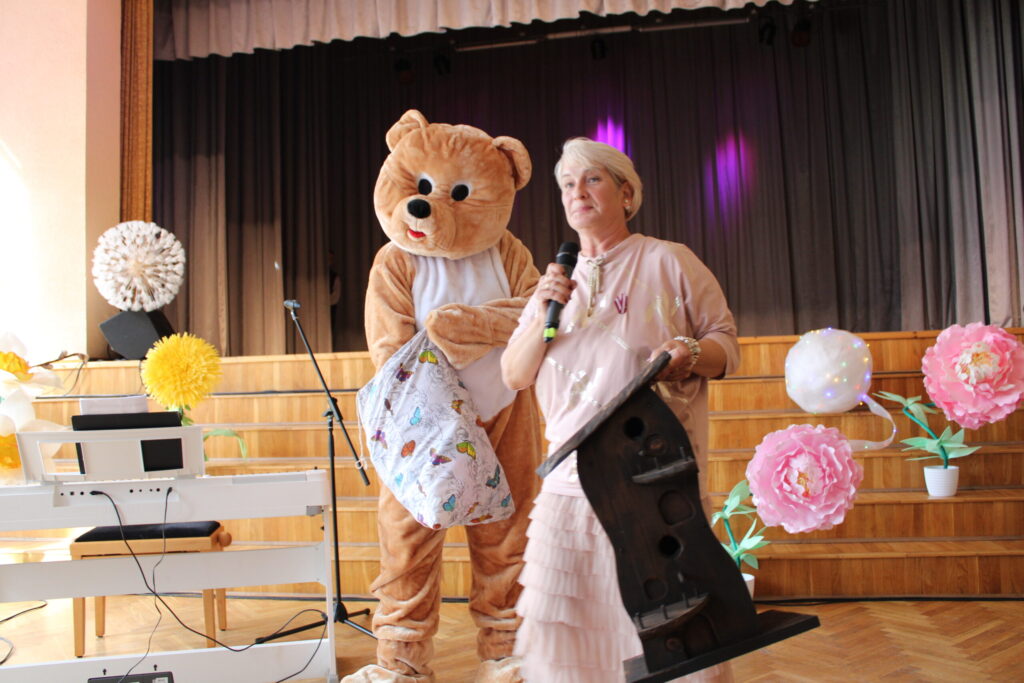 Grundzāles pagasta iedzīvotāju padomes sarīkotās loterijas balvu izlozi vadīja Sandra Elstiņa un Lācis (lāča maskā – Sintija Purgale), kuram Amanda sekoja līdzi ar lielu interesi.