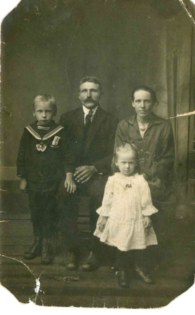 Šajā senajā, 1927. gadā uzņemtajā fotogrāfijā Lilijai Veronikai ir trīs gadi. Kopā ar viņu ir brālis Arvīds, mamma Emīlija un tētis Roberts.