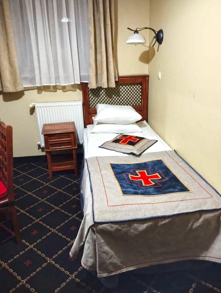 ĪPAŠS INTERJERS. Gultas klājums liecināja, ka šis ir Bruņinieku spārns.