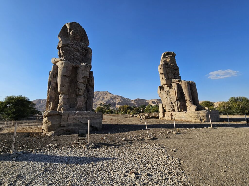 Memnona kolosi ir divas milzīgas, akmenī cirstas figūras kalnu pakājē, Senās Ēģiptes faraona Amenhotepa III akmens statujas.