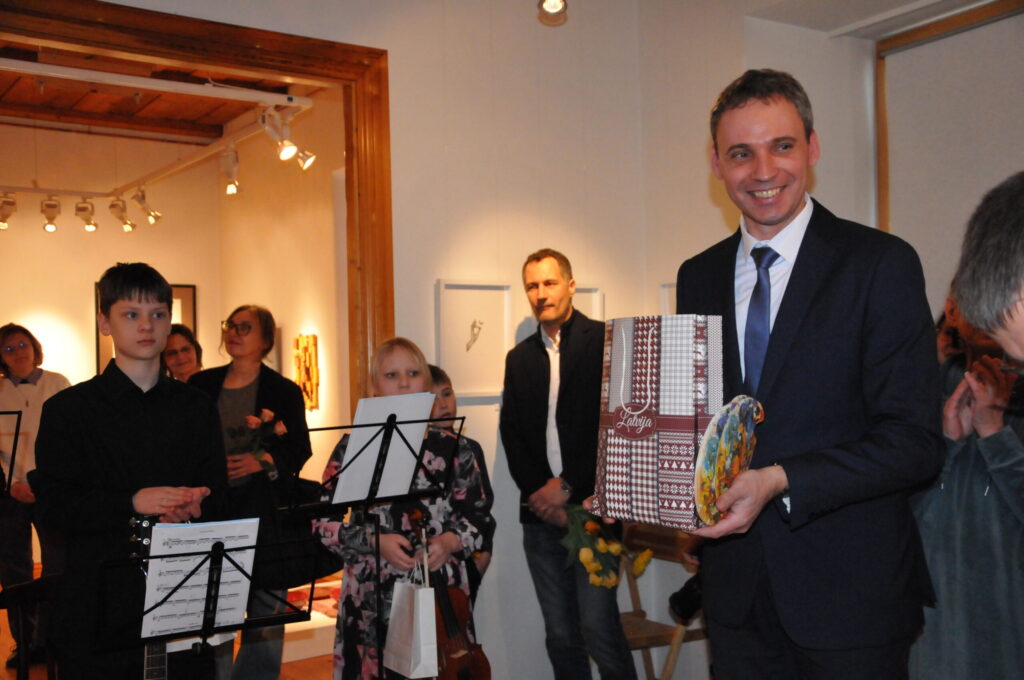 Valkas novadpētniecības muzeja direktors Reinis Kulbergs ar pateicību saņēma Valkas novada mākslinieku izstādes “Saskarsme” apmeklētāju dāvanas, kas pēc tam lieti noderēja pasākuma neformālajā daļā.