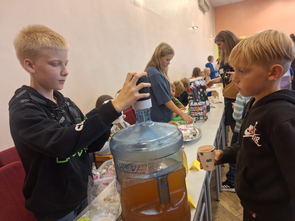 Klāvs Zandersons (no kreisās) pircējiem piedāvāja vienu no rudens TOP produktiem – ābolu sulu.