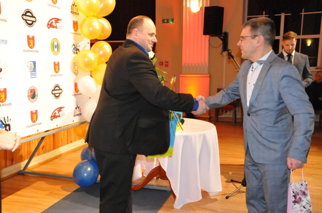 Savējo, vijciemieti, Latvijas čempionu folkreisā Gati Ģērmani (no kreisās) sirsnīgi sveic novada pašvaldības izpilddirektors Valdis Šaicāns.