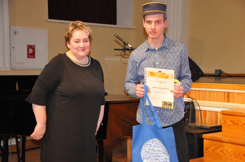 Angļu valodas skolotāja Ina Andiņa sveic Jāni Jaunslavieti par 1. vietu tulkotāju konkursā un par studijas vietas iegūšanu par valsts budžeta līdzekļiem studiju programmā “ Tulkošana un valodu tehnoloģija” Ventspils Augstskolā.