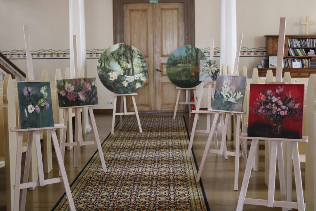 Eļļas tehnikā tapušo Adeles Bērziņas gleznu izlase, kas apskatāma izstādē Smiltenes luterāņu baznīcā, ir retrospektīvs atskats uz ziedu gleznojumiem. Māksliniece 2023. gadā absolvēja Latvijas Mākslas akadēmijas mākslas vēstures un teorijas nodaļu, iegūstot maģistra grādu vizuālajā mākslā. Viņas gleznojumi tapuši no ziedu studijām, klusās dabas uzstādījumiem, kā arī iedzīvinot ceļojumu iespaidus, piemēram, Babītes rododendru dārza kolekciju.