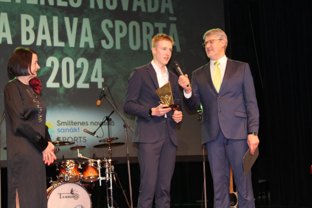 “Man tas ir pārsteigums. Paldies visiem atbalstītājiem,” saņemot Smiltenes novada domes priekšsēdētājas Astrīdas Harju (no kreisās) pasniegto pašvaldības balvu “Gada sportists 2024”, pasākuma vadītāja Aigara Veldres uzrunāts, pateicās šosejas riteņbraucējs, smiltenietis Olivers Jēkabs Skrapcis (vidū). Jaunais, talantīgais sportists ir vairākkārtējs Latvijas čempions, Latvijas Riteņbraukšanas federācijas šosejas ranga uzvarētājs 2024. gada sezonā, pārstāvējis Latviju Eiropas un pasaules čempionātā.