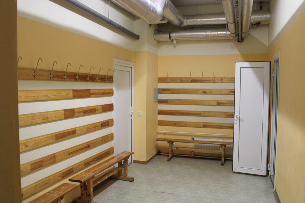 Vajadzības gadījumā patvertnei tiktu pielāgotas četras sporta halles sportistu ģērbtuves (attēlā) un atpūtas telpa. Visās telpās ir izlietne ar ūdens krānu, dušas telpa un labierīcības.