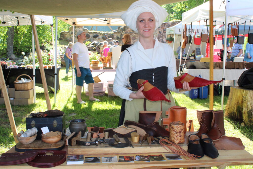 “Jo garāks purngals, jo augstāks stāvoklis sabiedrībā,” pašas darinātus 13 –15. gadsimtam raksturīgus kungu apavus demonstrē kurpniece Guna Zommere no biedrības “Rodenpois”.