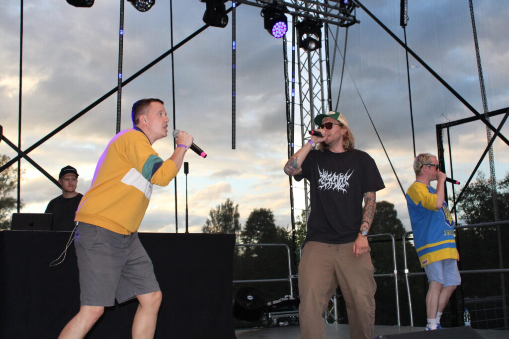 Ceturtdienas, 18. jūlija, vakarā Smiltenes pilsētas svētkos ar savu enerģiju “spridzināja” repa grupa “Singapūras Satīns”. Pēc koncerta viens no grupas mūziķiem Edgars Bāliņš (no labās) sociālajos tīklos (“X.com”) slavēja Smiltenes jauniešus, rakstot šādi: “Kulturālākie jaunieši Latvijā aug Smiltenē. Ja citur prasa bildes, autogrāfus, video sveicienus draugiem, tad šeit palūdza kopīgi uzdziedāt. Pirmoreiz 10 gadu laikā, un veselas 2 x dažādi jaunieši. Un ne šādas tādas dziesmas, bet “Circenīša Ziemassvētkus” un “Tā kā sievietes”.