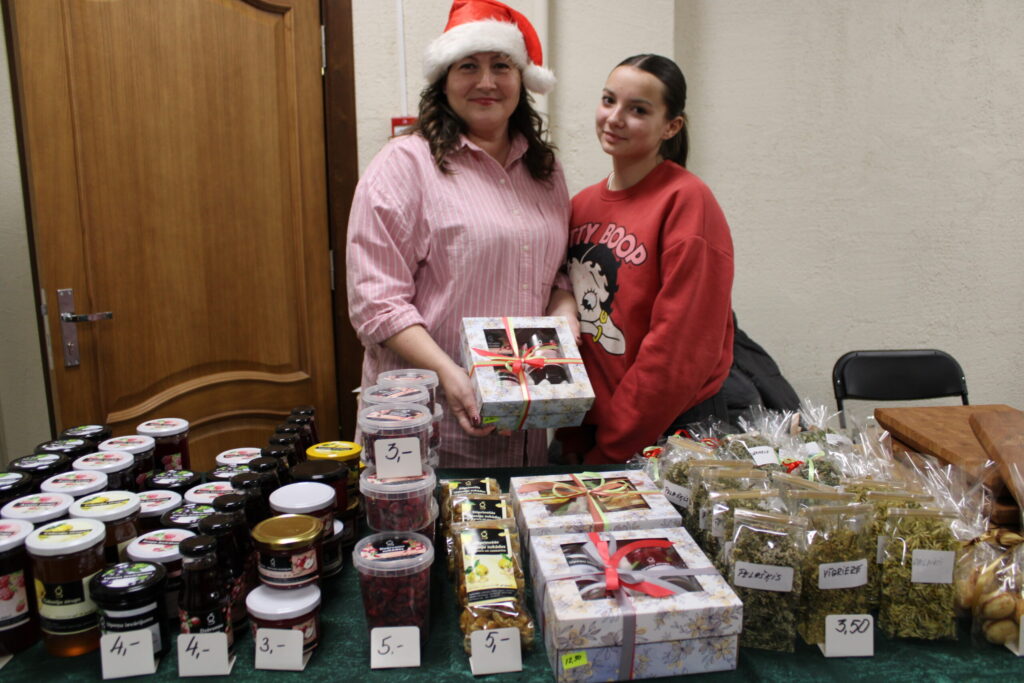 Variņu pagasta iedzīvotāju padomes locekle Ilze Krevica (attēlā ar meitu Martu) vēlas, lai šādi kopīgi pasākumi ne tikai saliedē vietējos cilvēkus, bet arī izceļ saulītē viņu prasmes. Ilze pati ir mājražotāja, tirdziņā viņa piedāvāja dažādus labumus no savas saimniecības un nedaudz arī no kaimiņu audzētās ražas – upeņu, aveņu, dzērveņu un cidoniju sīrupus, upeņu ievārījumu, dzērveņu un cidoniju sukādes un dažādas augu tējas. Tās Ilze sākusi vākt tikai šogad.