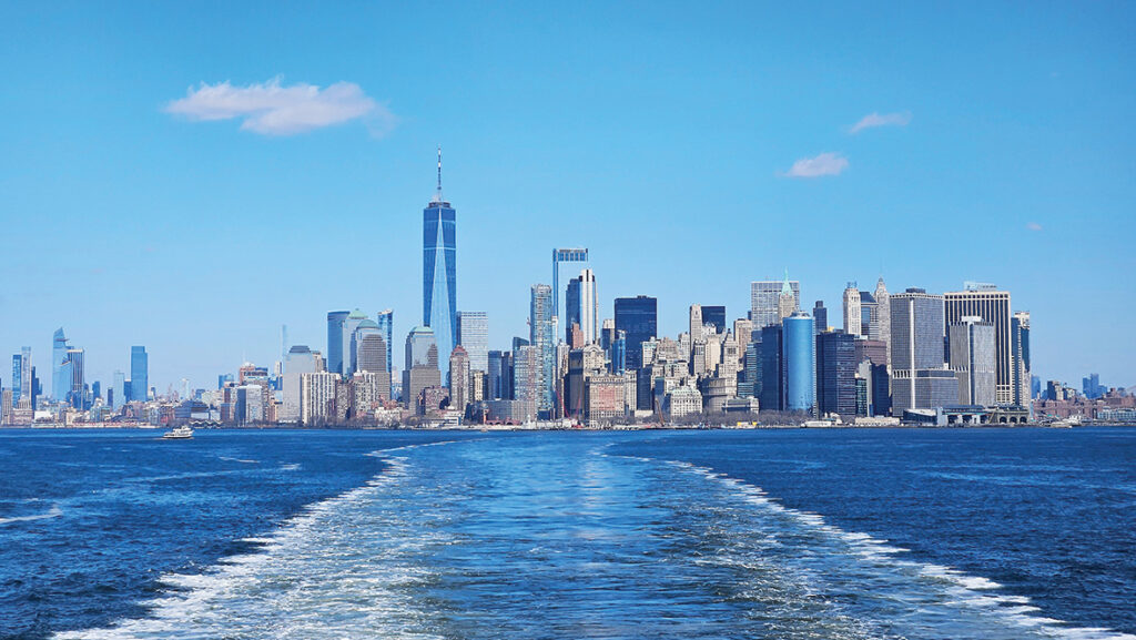 Ceļā ar prāmi lūkot Brīvības statuju. Krastā paliek Manhetena.